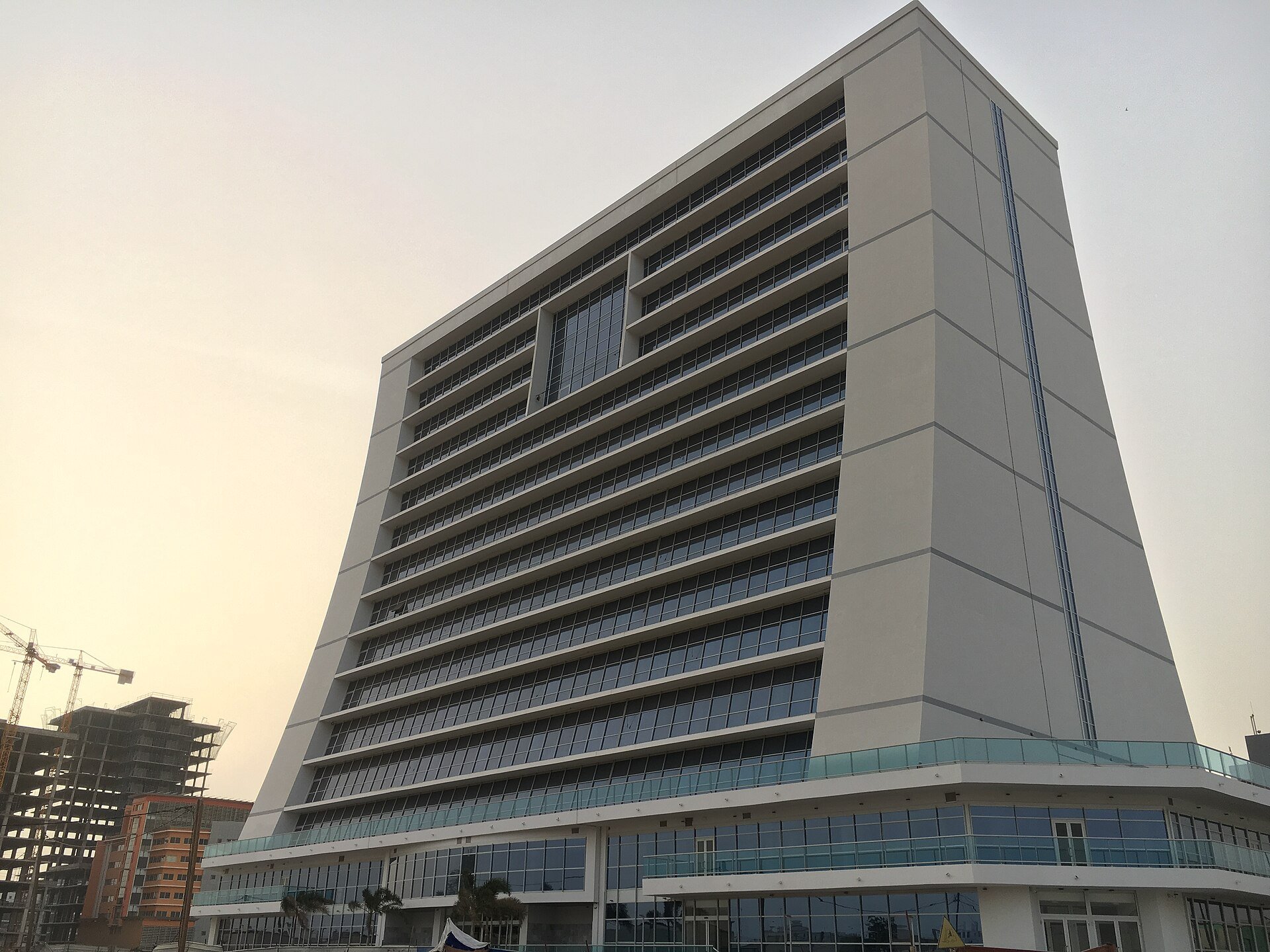 The tall white headquarters tower of the SNIM iron ore company in Nouakchott, Mauritania, seen from street level