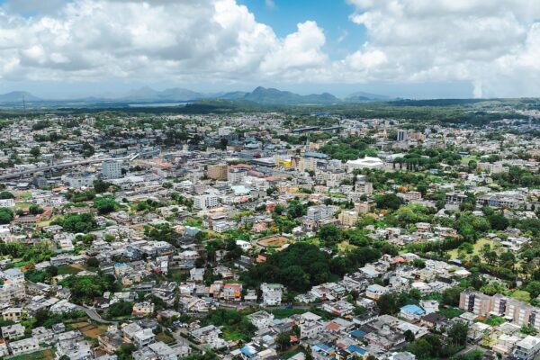 Aerial view of Curepipe, a highland town in central Mauritius, with rooftops, trees and mountains on the horizon