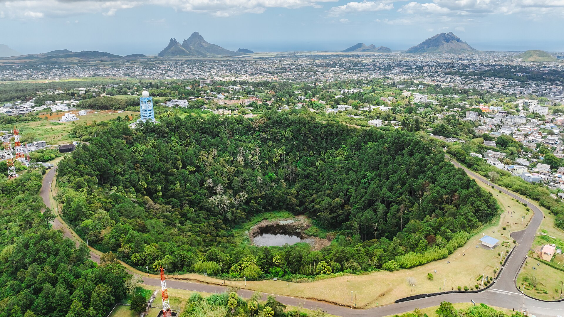 Forested Trou aux Cerfs volcanic crater with a small pool at its floor, beside the town of Curepipe in Mauritius