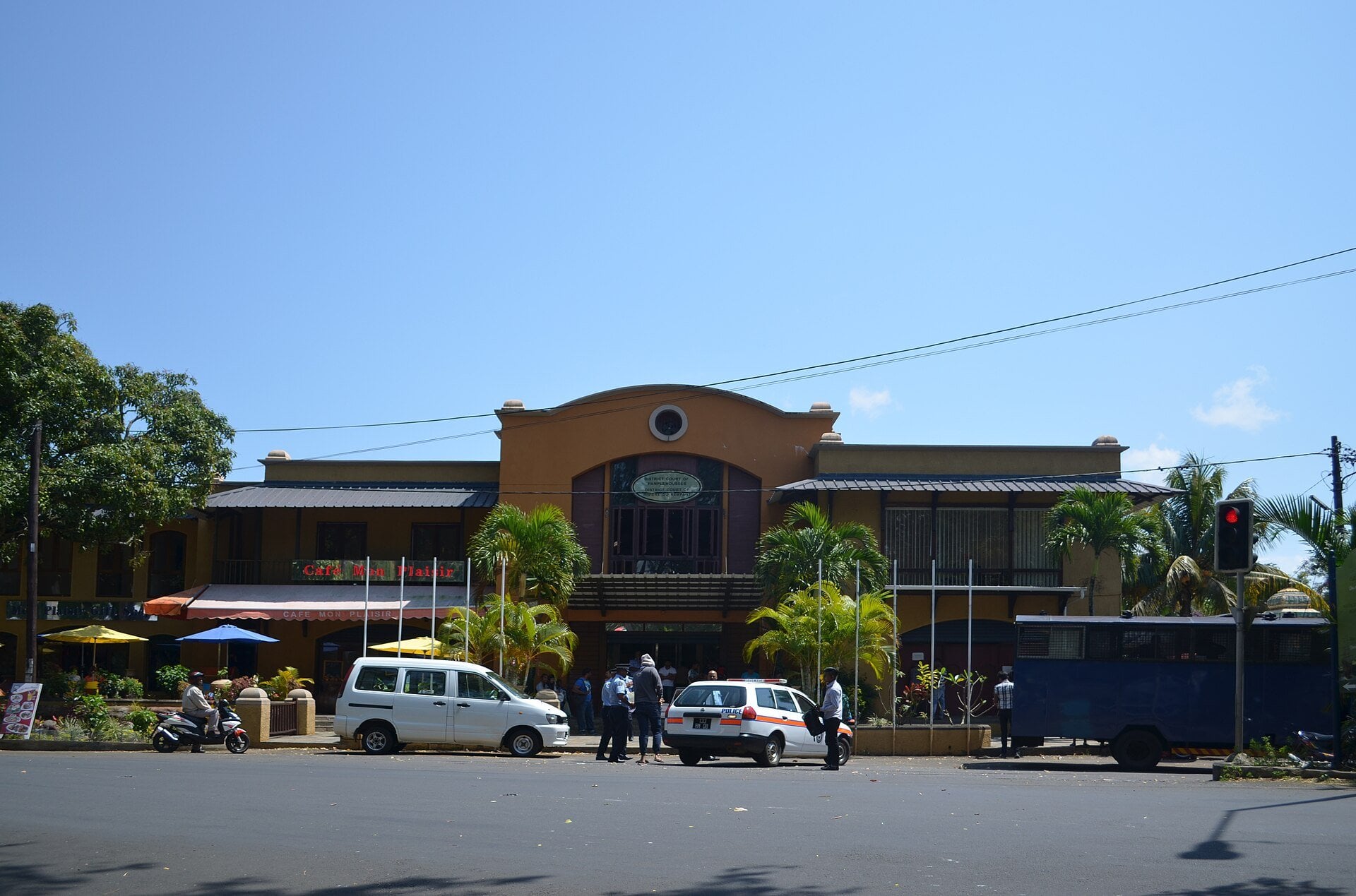 District court building in Pamplemousses, Mauritius, with a police car and a prison van parked in front
