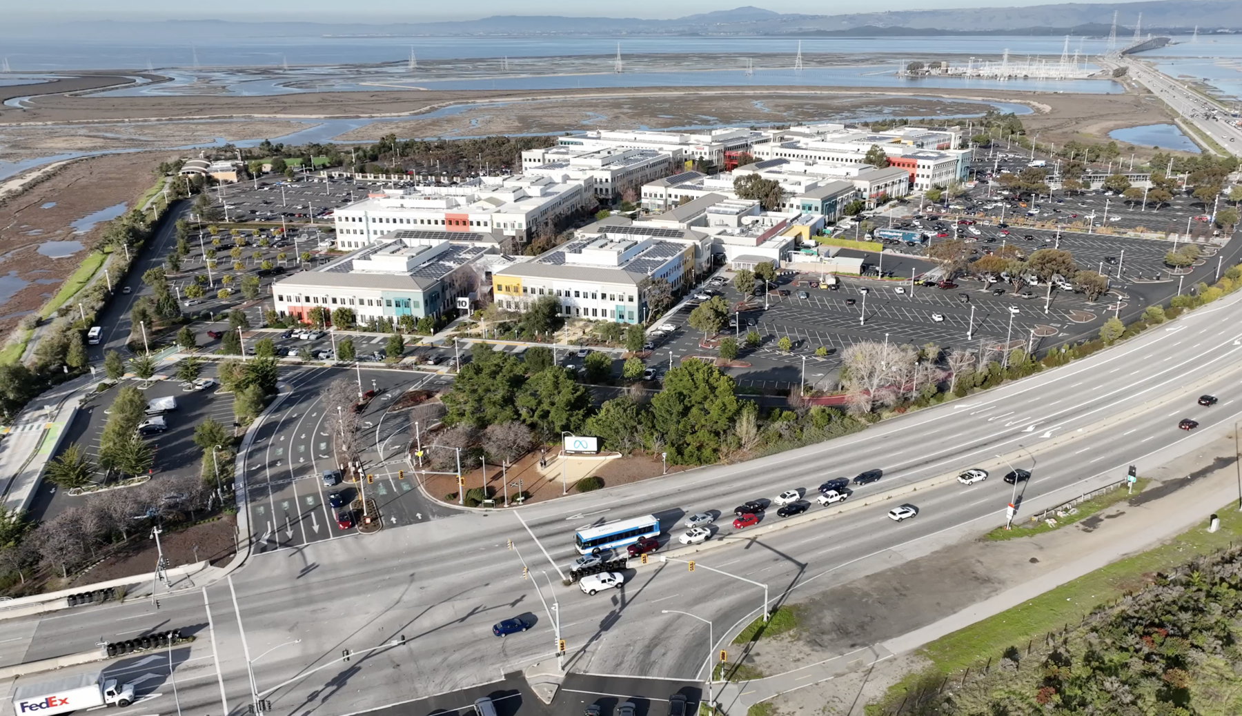 Aerial view of the Meta headquarters campus in Menlo Park, California, beside a highway and the bay