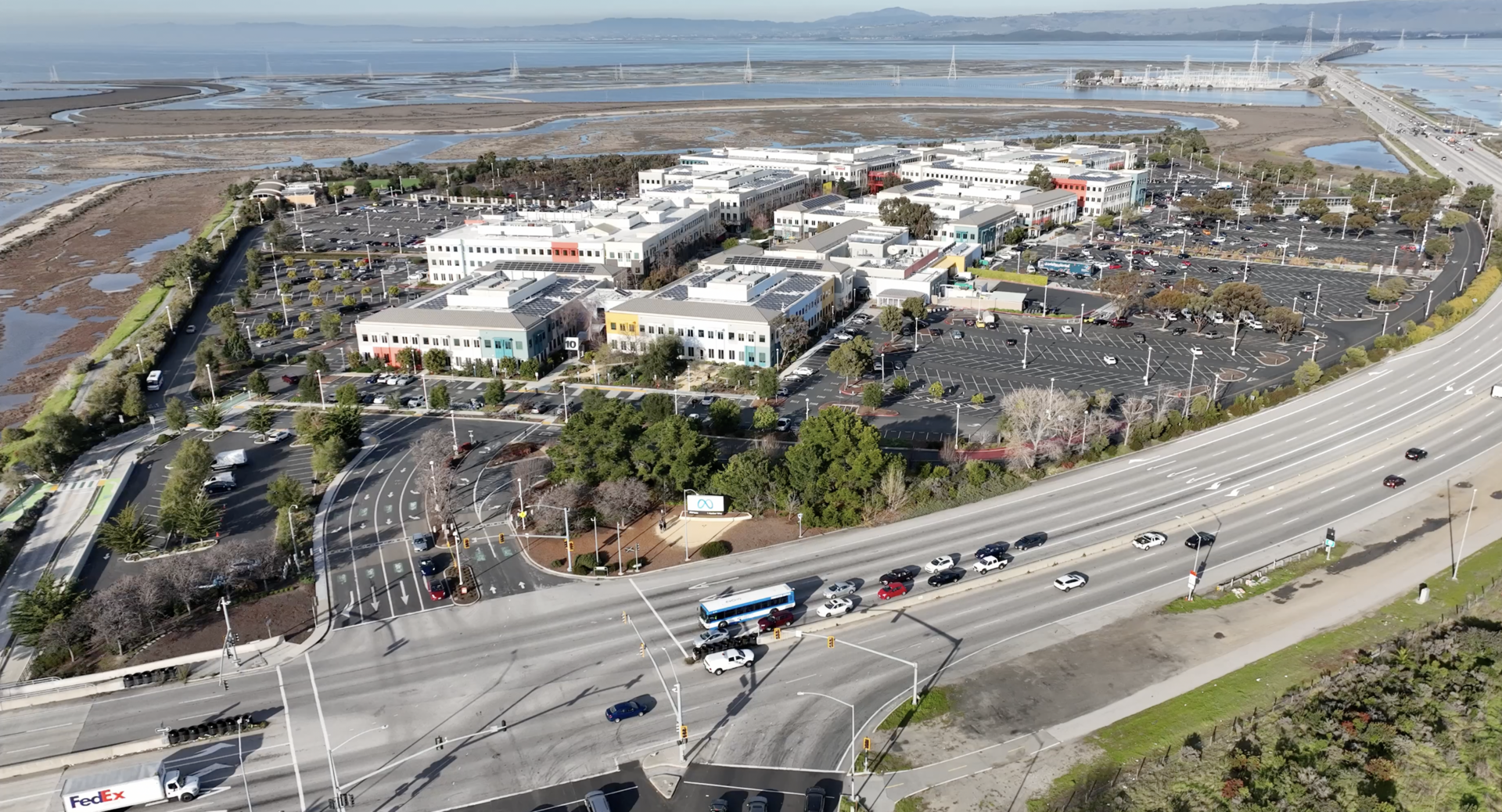 Aerial view of the Meta headquarters campus in Menlo Park, California, beside a highway and the bay