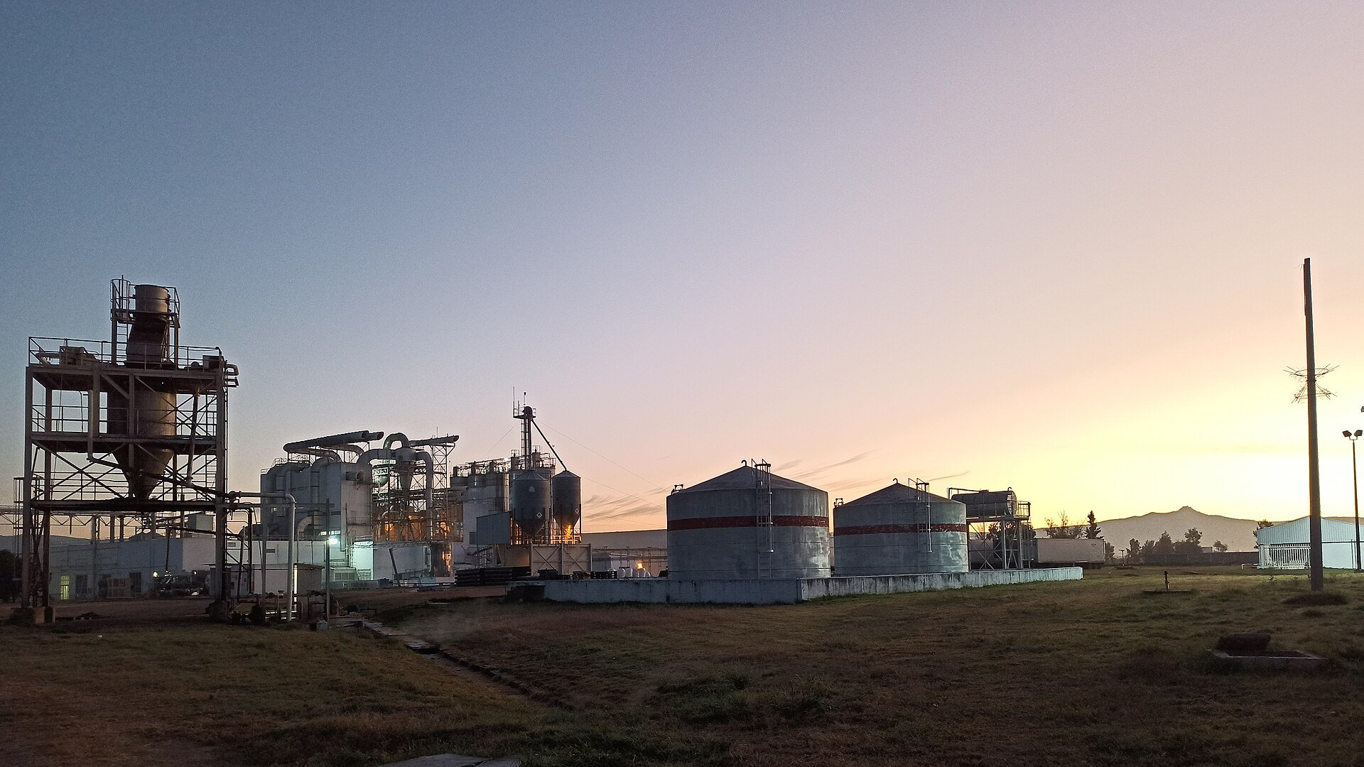 Industrial plant with storage tanks at sunrise in the El Bajio industrial corridor near Silao, Guanajuato