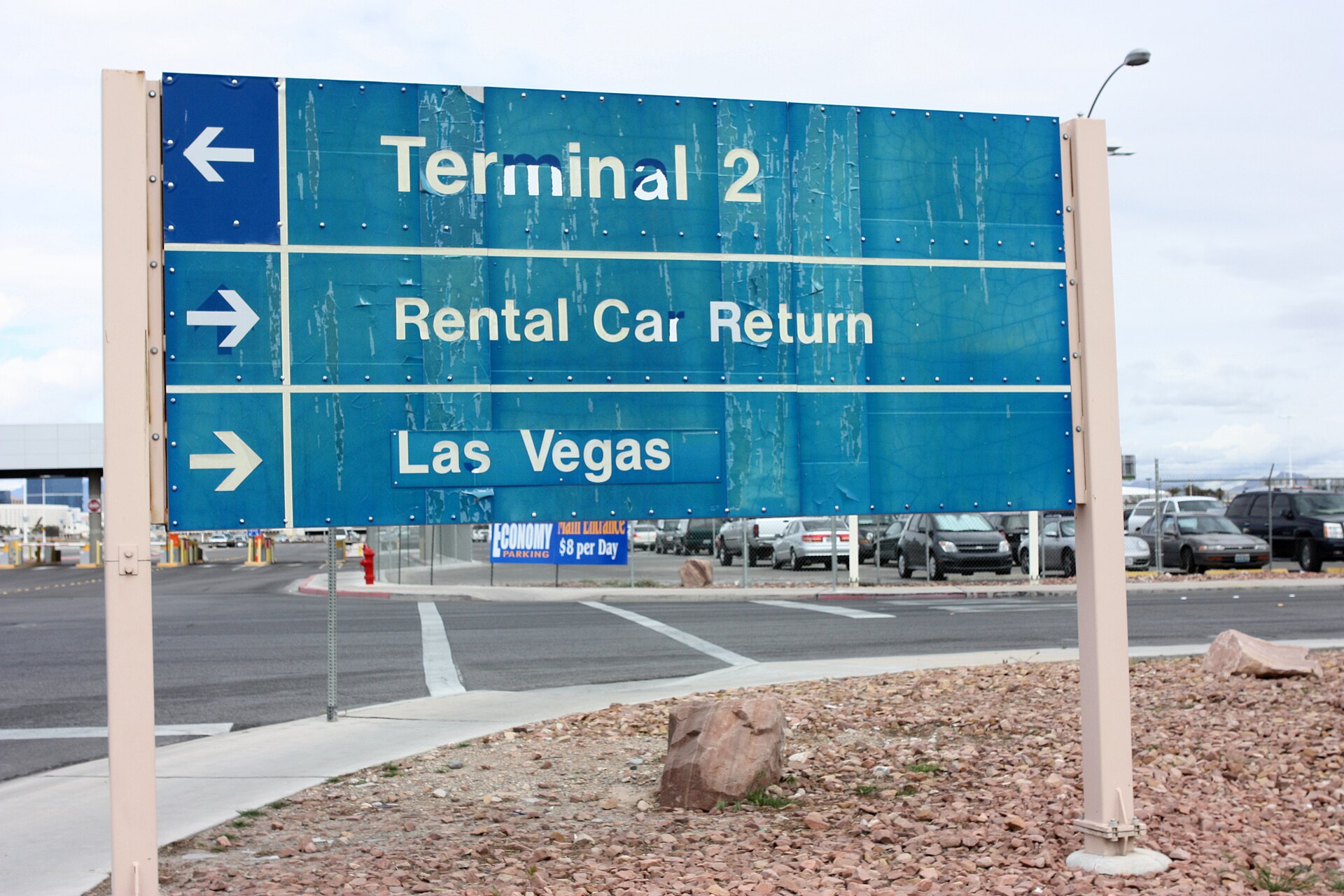 Rental Car Return sign at the Las Vegas airport with parked cars behind