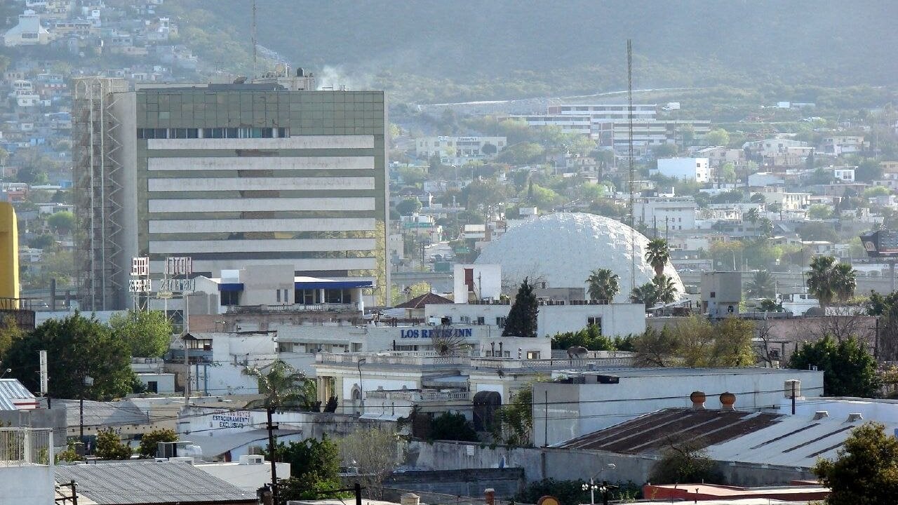 Cemex corporate office building and the Rio 70 theater dome in Monterrey, Mexico, seen against the hills