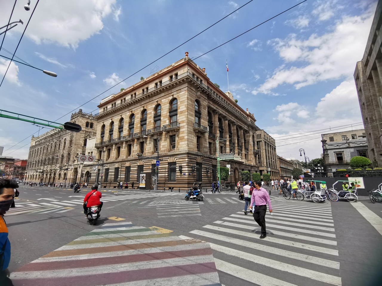 The historic Bank of Mexico building at a busy street corner in central Mexico City