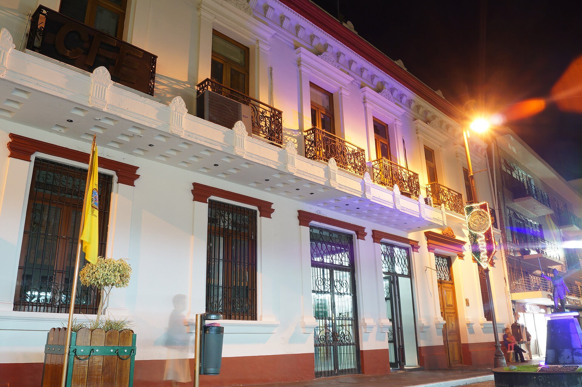 The white colonial-style CFE office building in Orizaba, Veracruz, lit at night with its CFE sign on the balcony