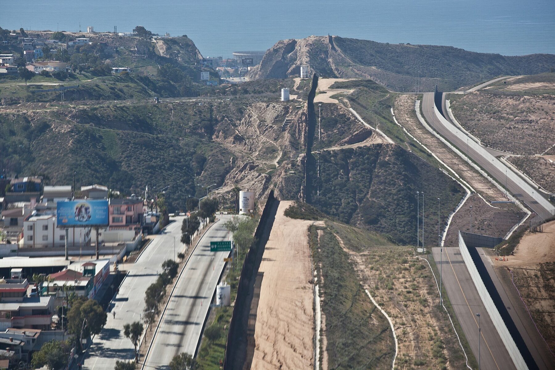 Aerial view of the US-Mexico border fence climbing a hillside near San Diego and Tijuana