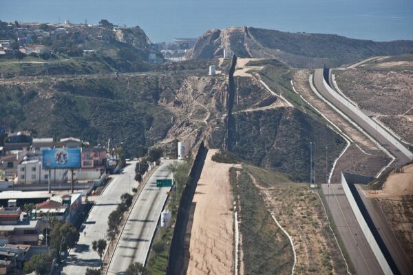 Aerial view of the US-Mexico border fence climbing a hillside near San Diego and Tijuana