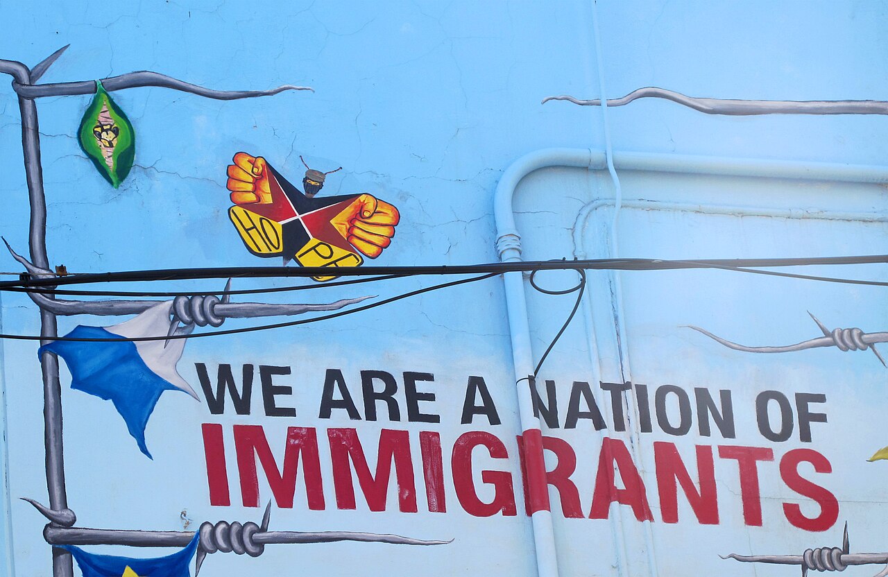 A painted wall mural in Chicago with barbed wire and the words We Are a Nation of Immigrants.