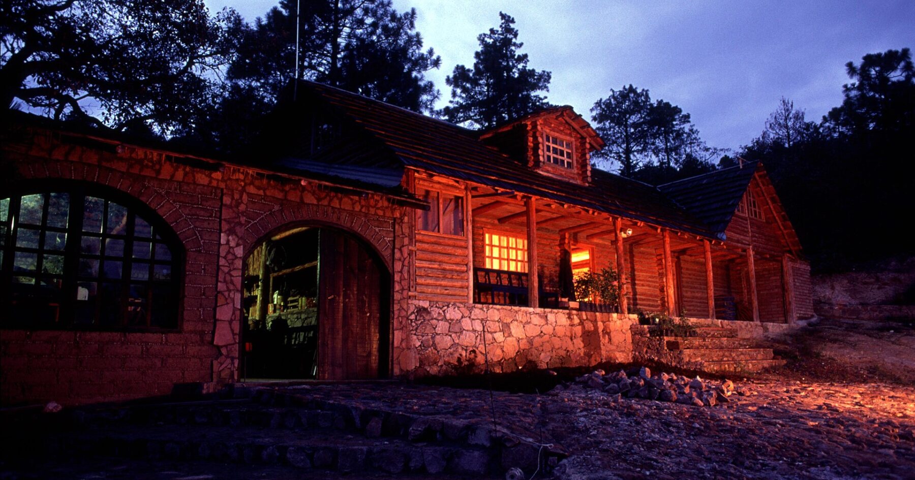 Log house lit at dusk among pine trees in Guachochi, Chihuahua, in the Sierra Tarahumara