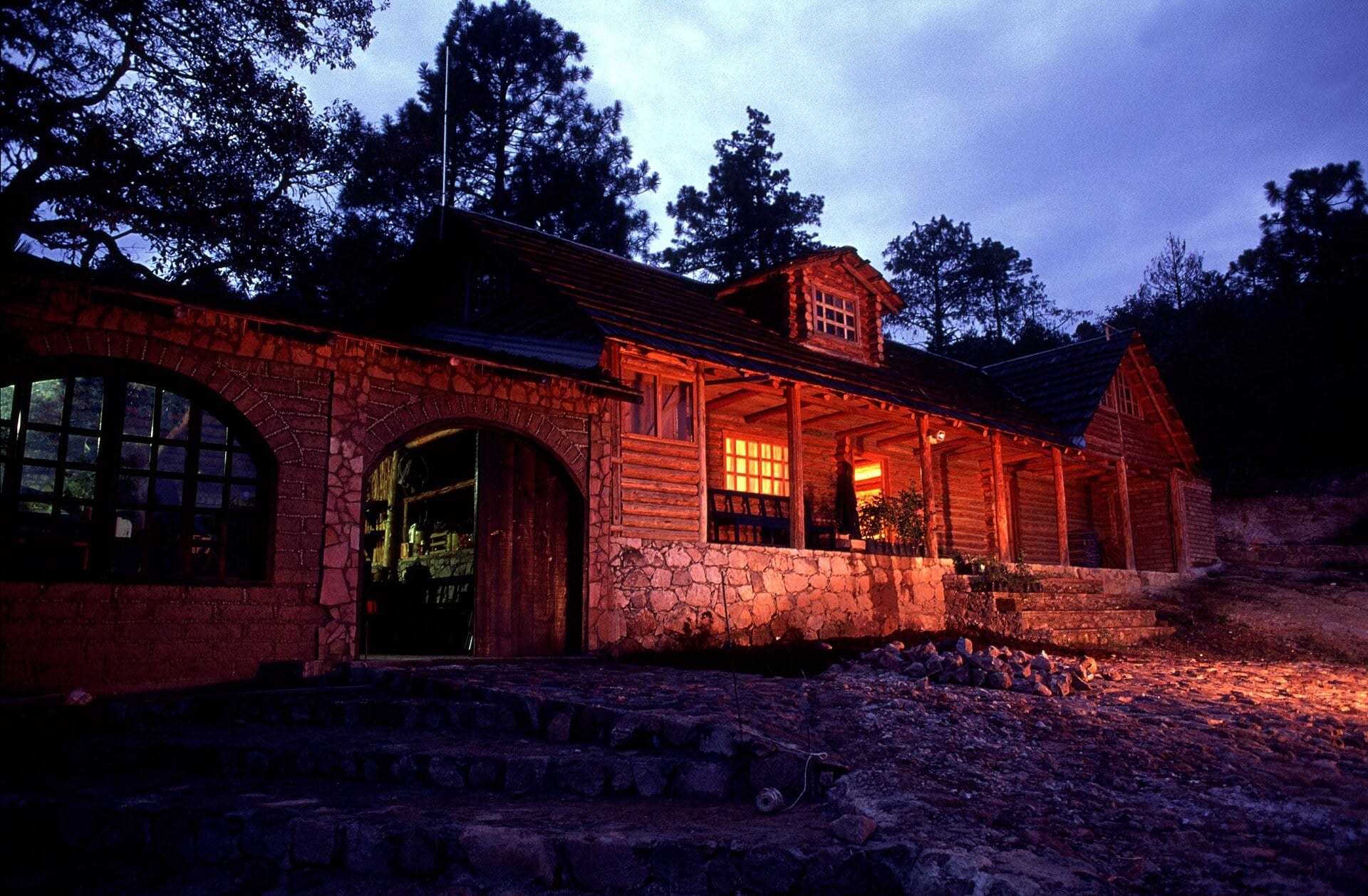 Log house lit at dusk among pine trees in Guachochi, Chihuahua, in the Sierra Tarahumara
