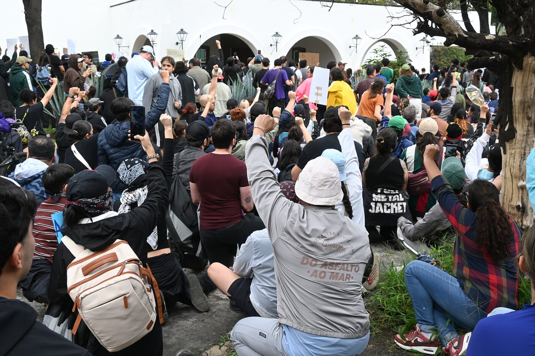 Protesters kneel with raised fists outside Casa Jalisco in Guadalajara during the march for clean water