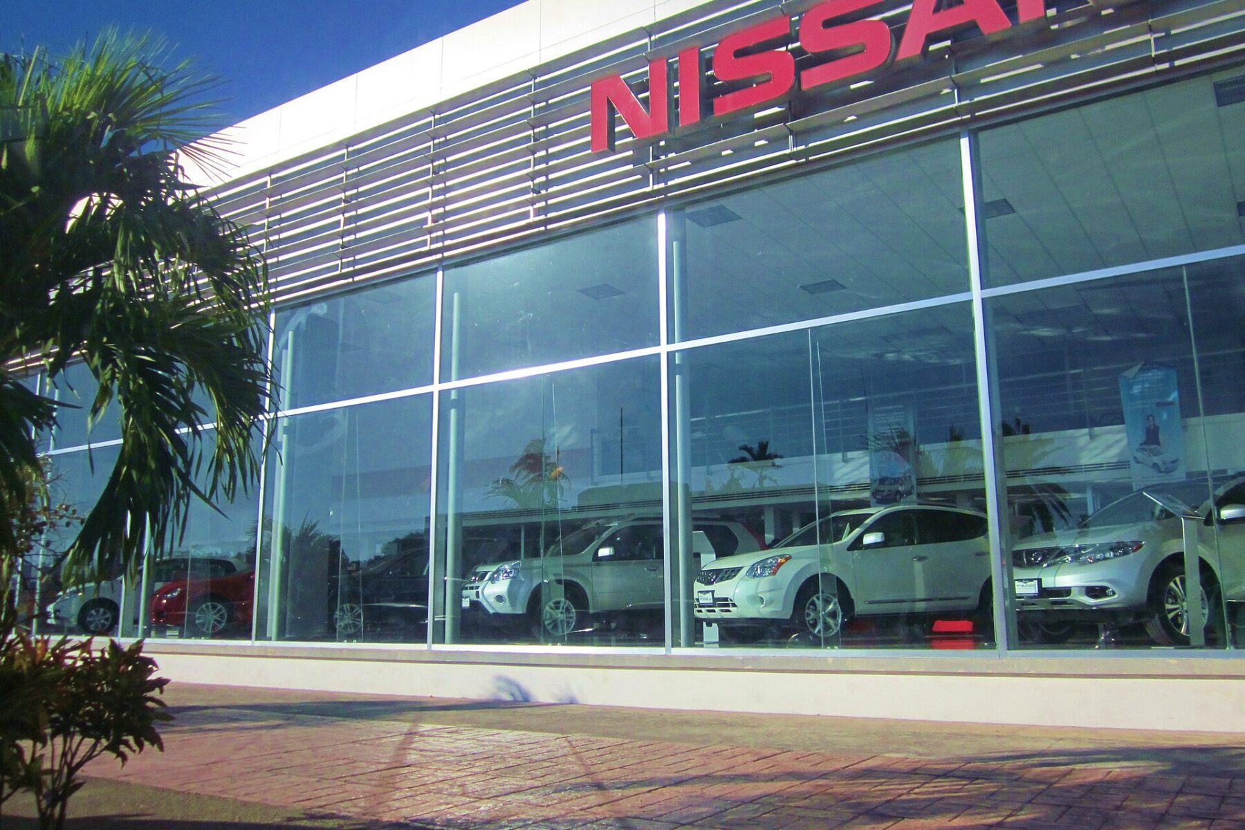 A Nissan dealership showroom with cars behind glass in Chetumal, Quintana Roo, Mexico