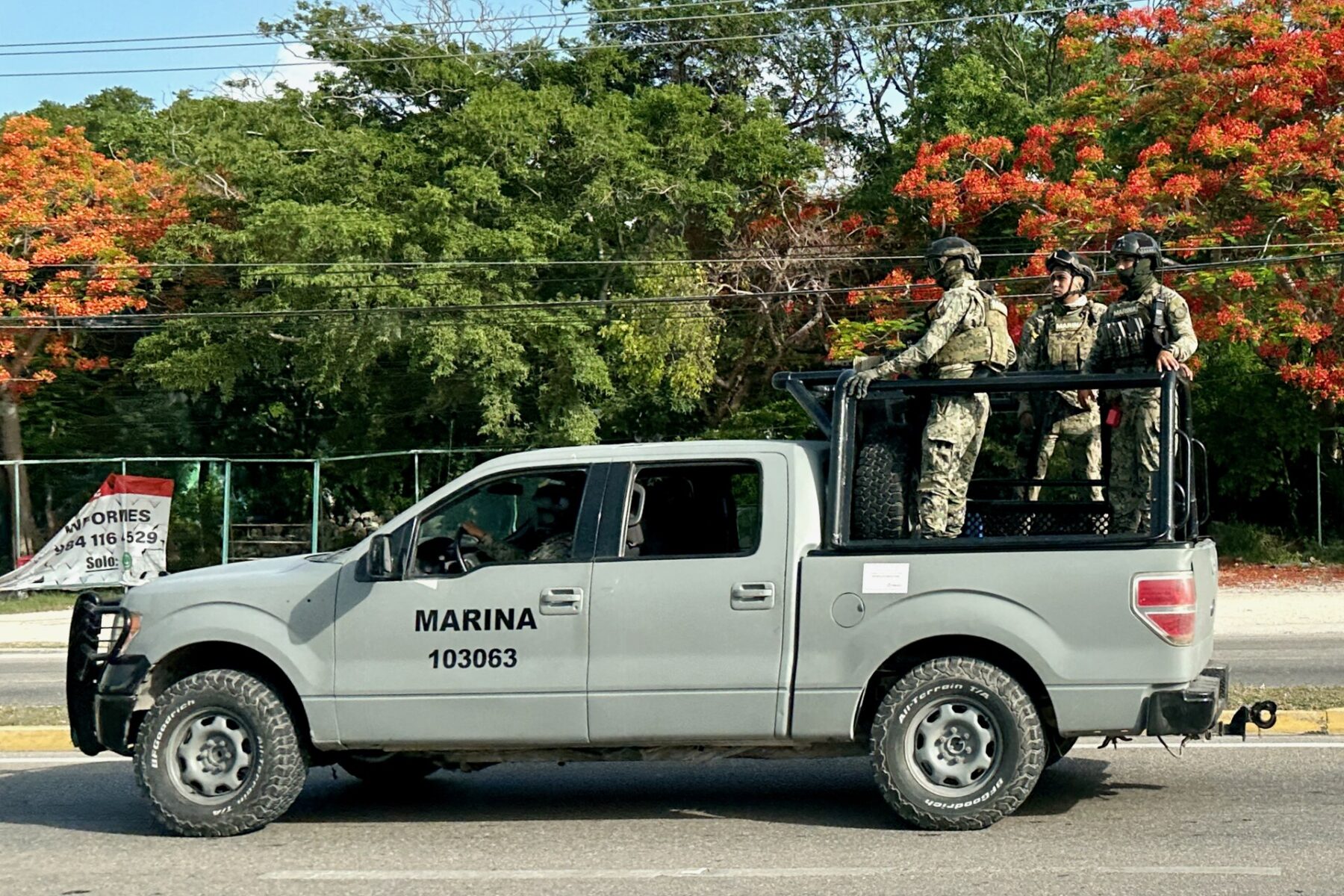 Mexican Navy pickup truck carrying three armed marines in camouflage on a road in Mexico