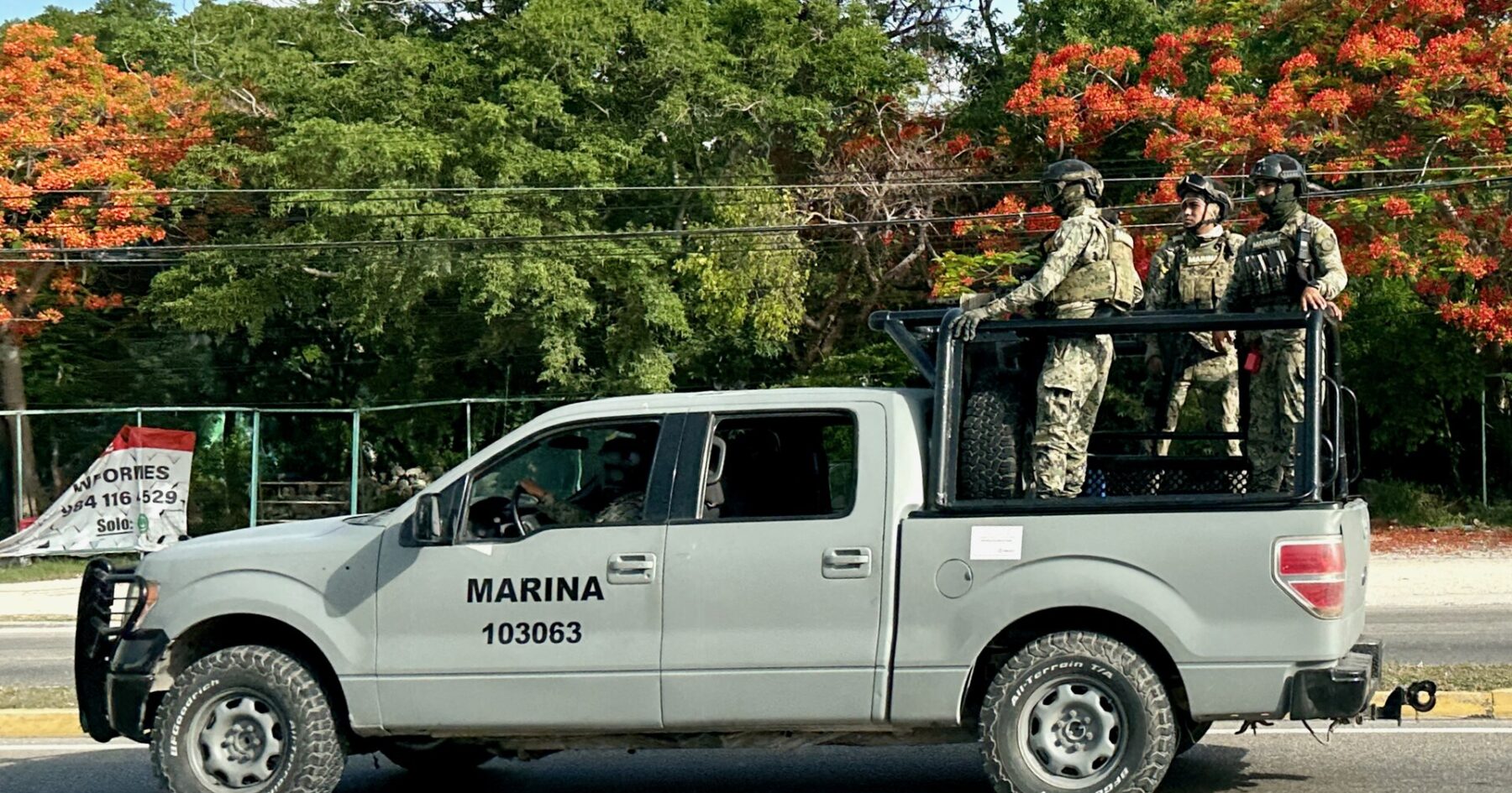 Mexican Navy pickup truck carrying three armed marines in camouflage on a road in Mexico