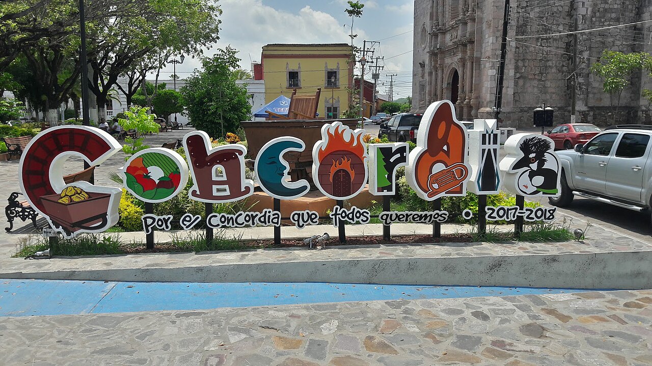Colourful letters spelling Concordia stand in front of a stone church on the town square in Sinaloa