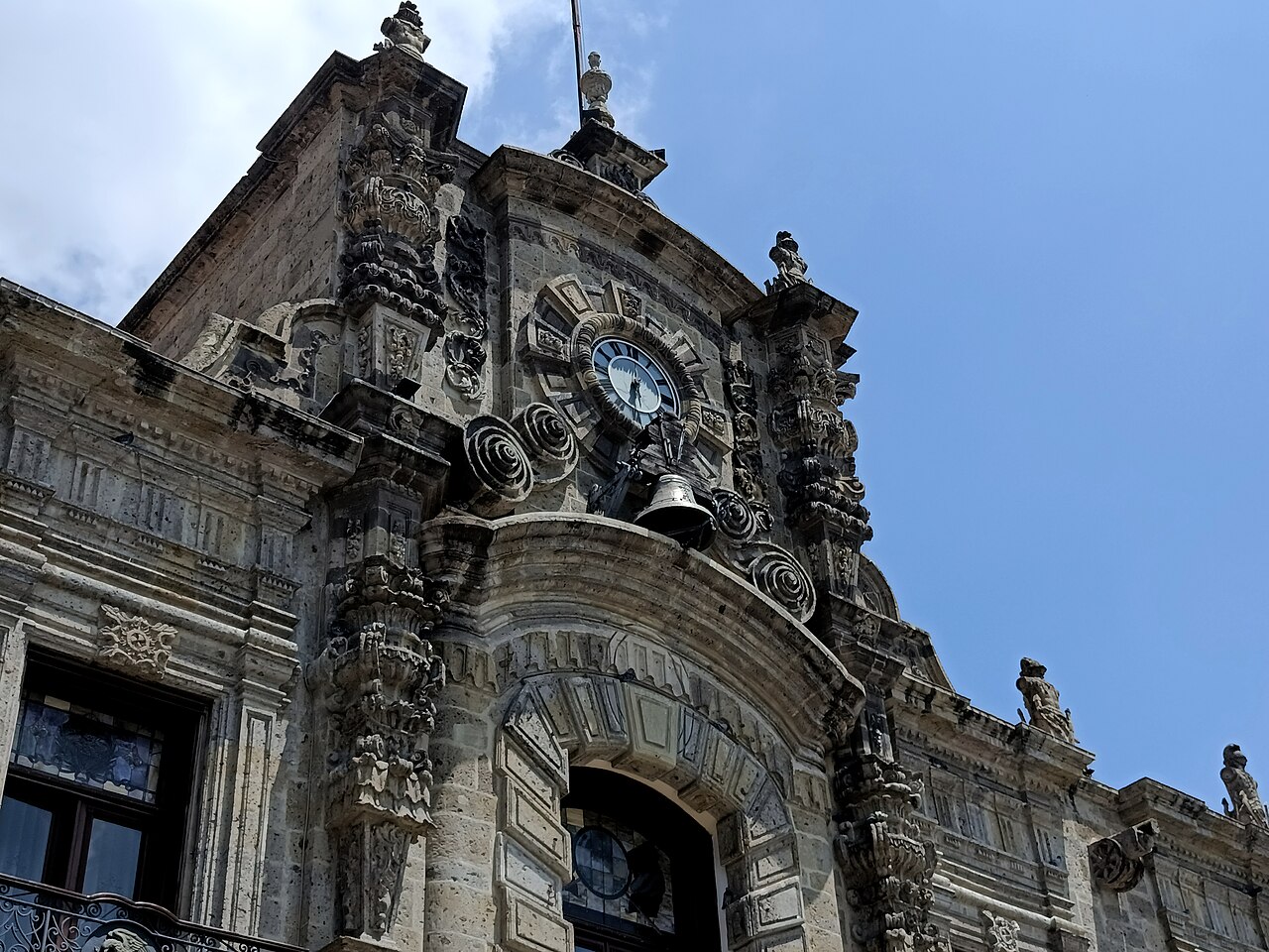 Carved stone clock tower and bell above the main entrance of the Jalisco Government Palace in Guadalajara