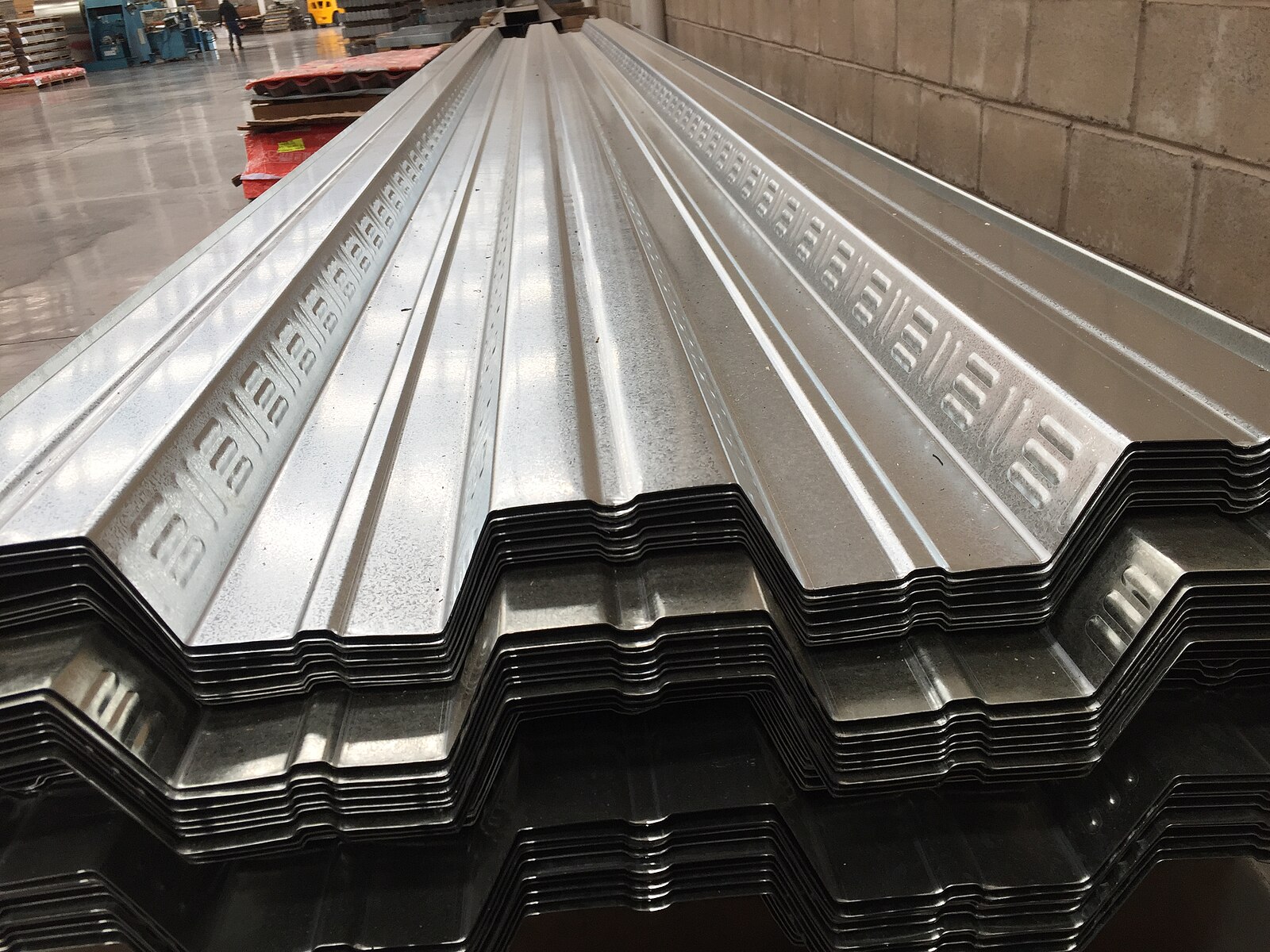 Stacked galvanised steel sheets in a warehouse, the kind of product hit by a 50% US steel tariff