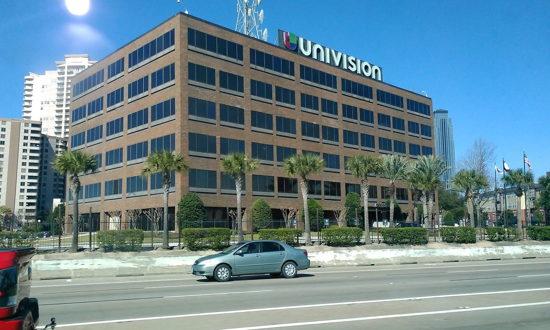 The six-story brick Univision building in Houston, Texas, with the Univision logo and a transmission tower on its roof