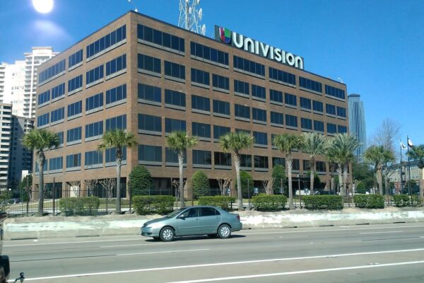 The six-story brick Univision building in Houston, Texas, with the Univision logo and a transmission tower on its roof