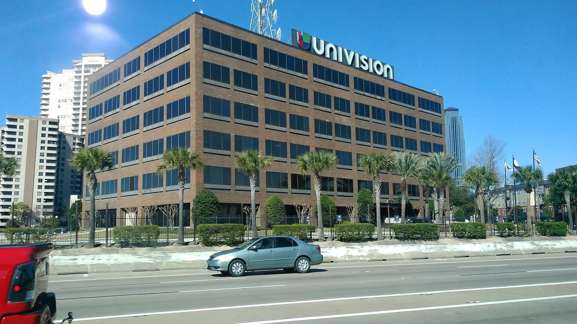 The six-story brick Univision building in Houston, Texas, with the Univision logo and a transmission tower on its roof