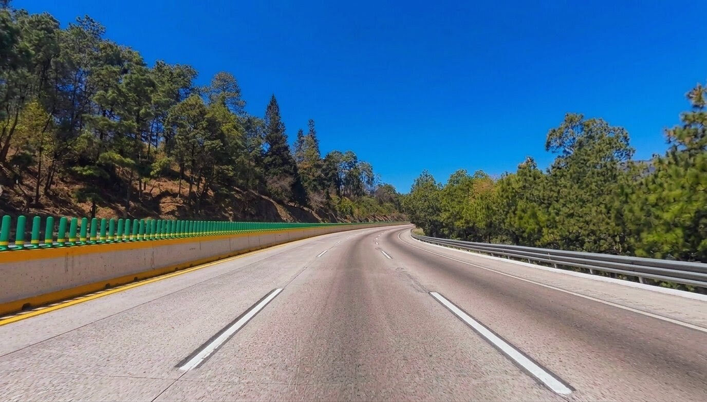The Mexico City to Puebla highway curves through pine forest in central Mexico