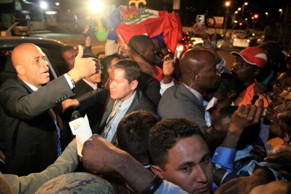 Michel Martelly, then president of Haiti, arrives in Quito, Ecuador, in July 2012 amid a crowd holding a Haitian flag