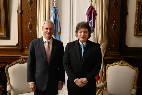 Argentina's President Javier Milei and Chile's President José Antonio Kast standing side by side in a formal room with their national flags