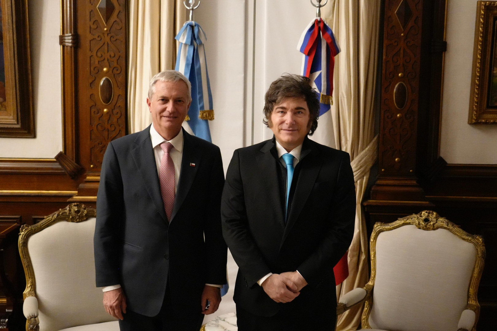 Argentina's President Javier Milei and Chile's President José Antonio Kast standing side by side in a formal room with their national flags