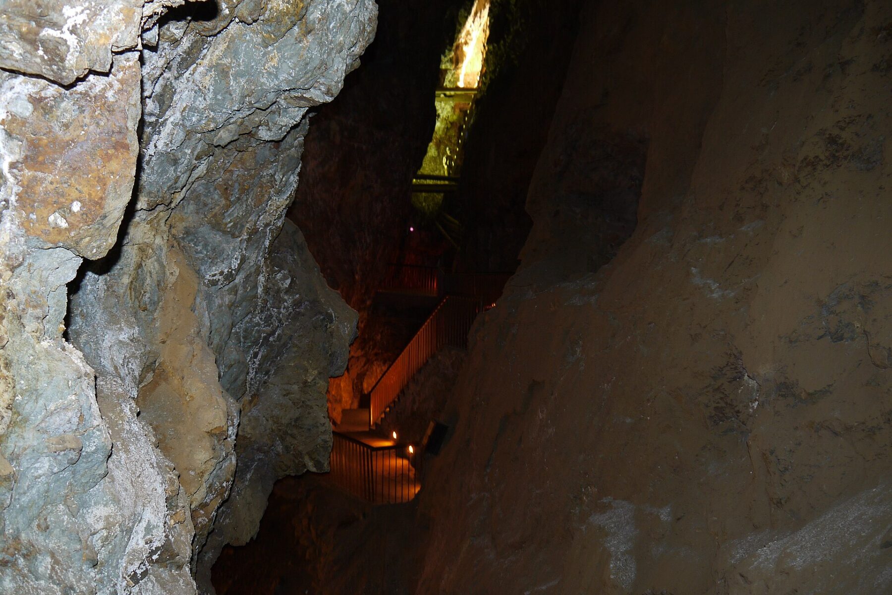 A lit walkway descending through a rock-walled shaft inside the El Edén silver mine in Zacatecas, Mexico