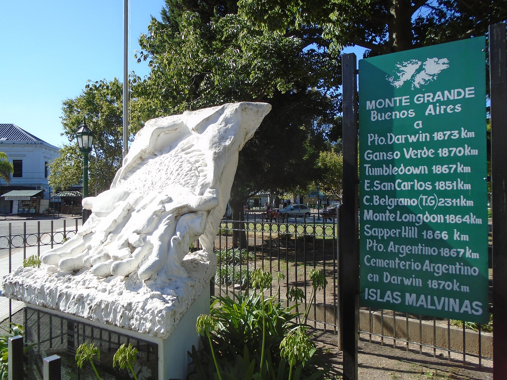 The Malvinas memorial and a distance sign on the Plaza de los Fundadores in Monte Grande, Buenos Aires Province, Argentina