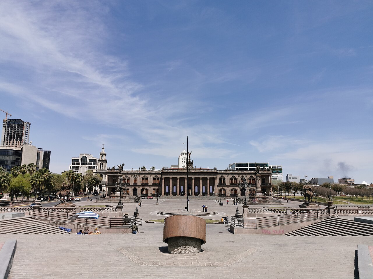 The stone Palacio de Gobierno of Nuevo León seen across the Explanada de los Héroes plaza in Monterrey under a blue sky