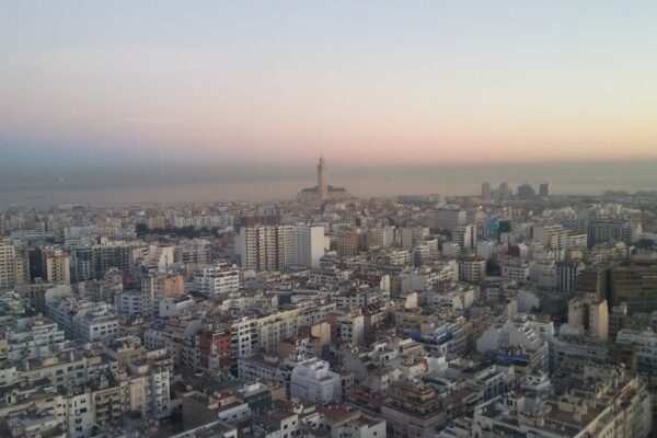 Morocco media: rooftop satellite dishes across Casablanca with the Hassan II Mosque on the horizon