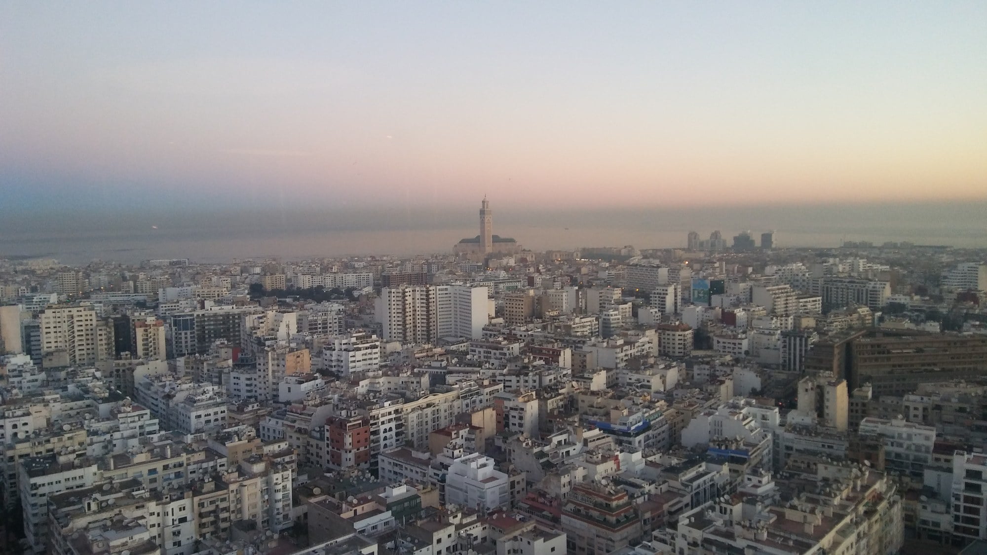 Morocco media: rooftop satellite dishes across Casablanca with the Hassan II Mosque on the horizon