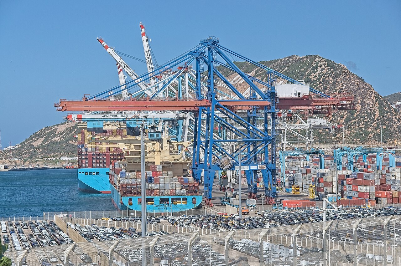 Container ship Maersk Congo at a Tanger Med quay, with rows of new cars parked in the foreground