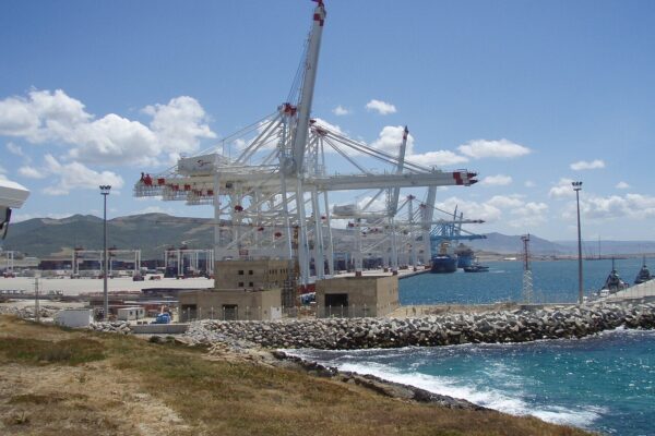 Container cranes and quay at Tanger Med port on Morocco's Strait of Gibraltar coast, with hills behind
