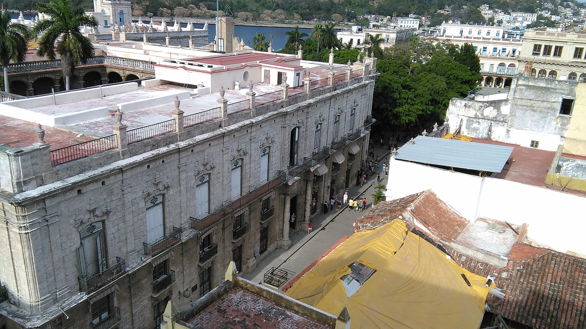 Old Havana rooftops and a colonial street seen from above, with Havana Bay behind