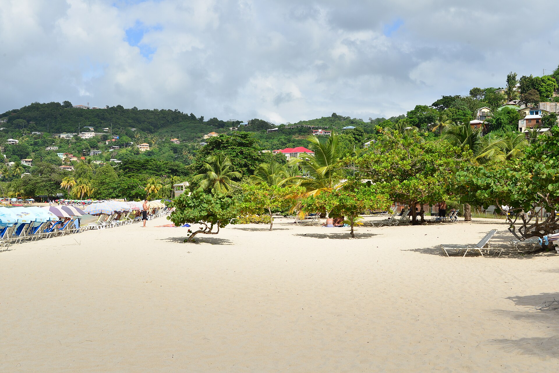 Grand Anse beach in Grenada with houses on the green hills behind