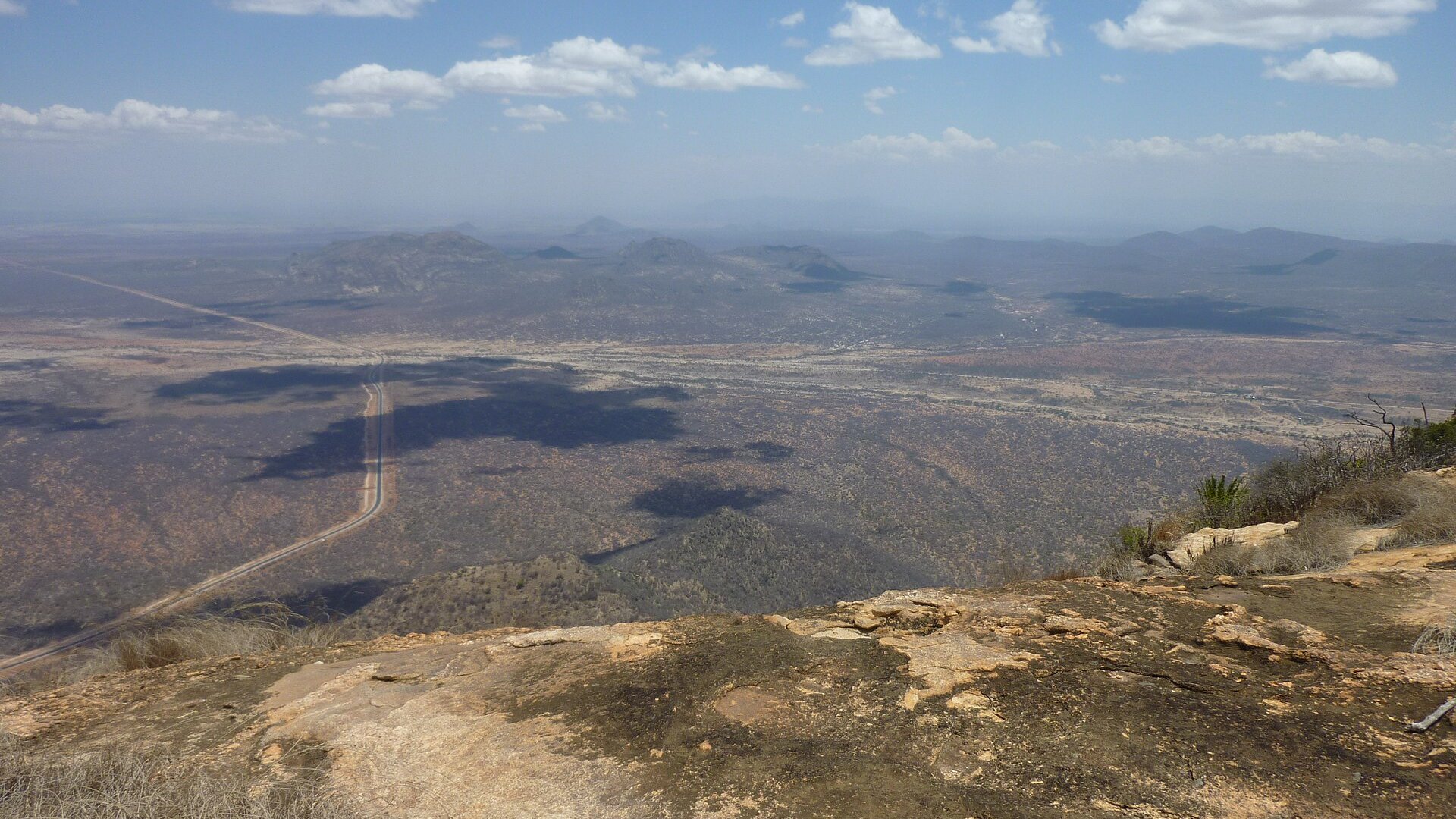 Paved road crossing the dry plains of northern Kenya between Marsabit and Moyale, seen from a hilltop
