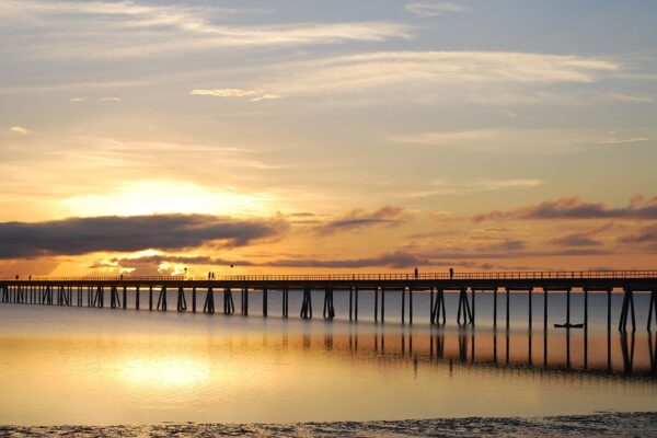 Long wooden footbridge over calm water at sunset linking the Island of Mozambique to the mainland