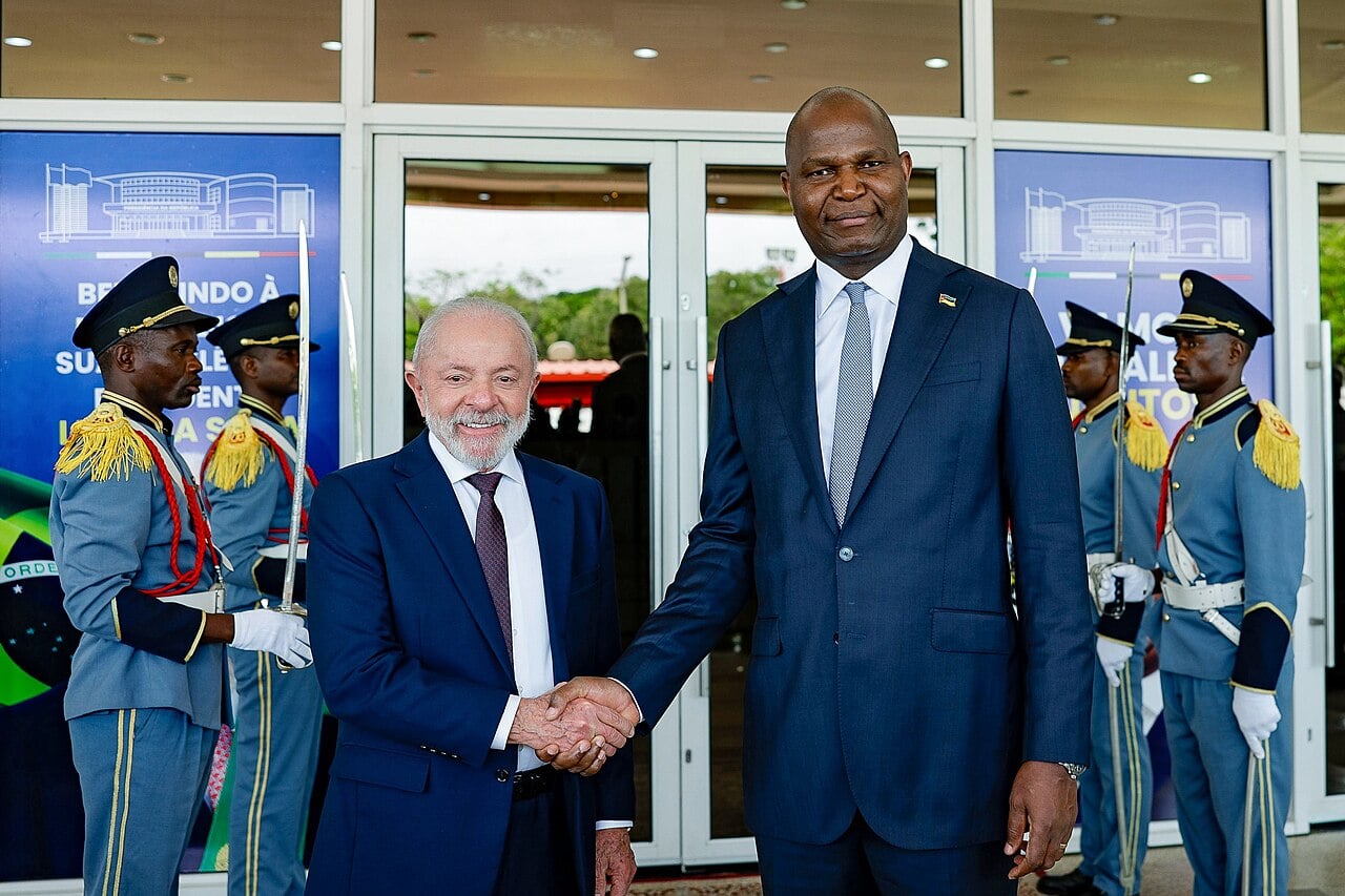 President Daniel Chapo of Mozambique shakes hands with Brazil's President Lula at the Presidential Palace in Maputo, with a ceremonial guard behind them.