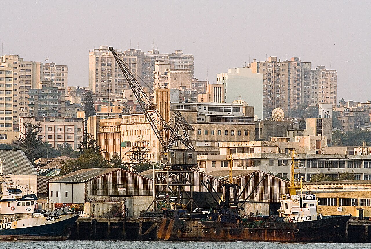 Harbour crane, fishing boats and apartment blocks on the waterfront at Maputo, Mozambique