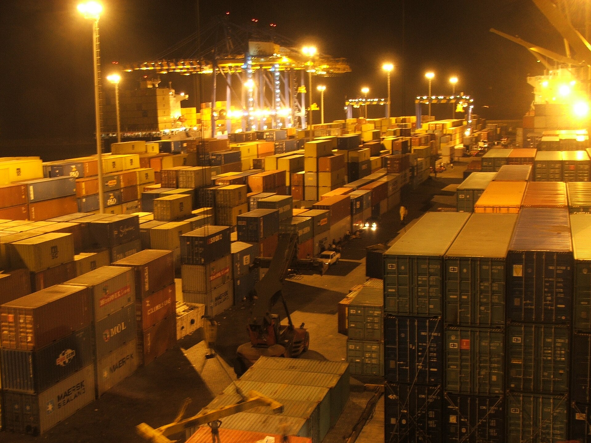 Container stacks and cranes at the port of Tema, Ghana, at night