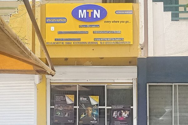 A yellow MTN Data Partners shopfront with the red-and-blue MTN logo on Bukar Road in Kano, Nigeria