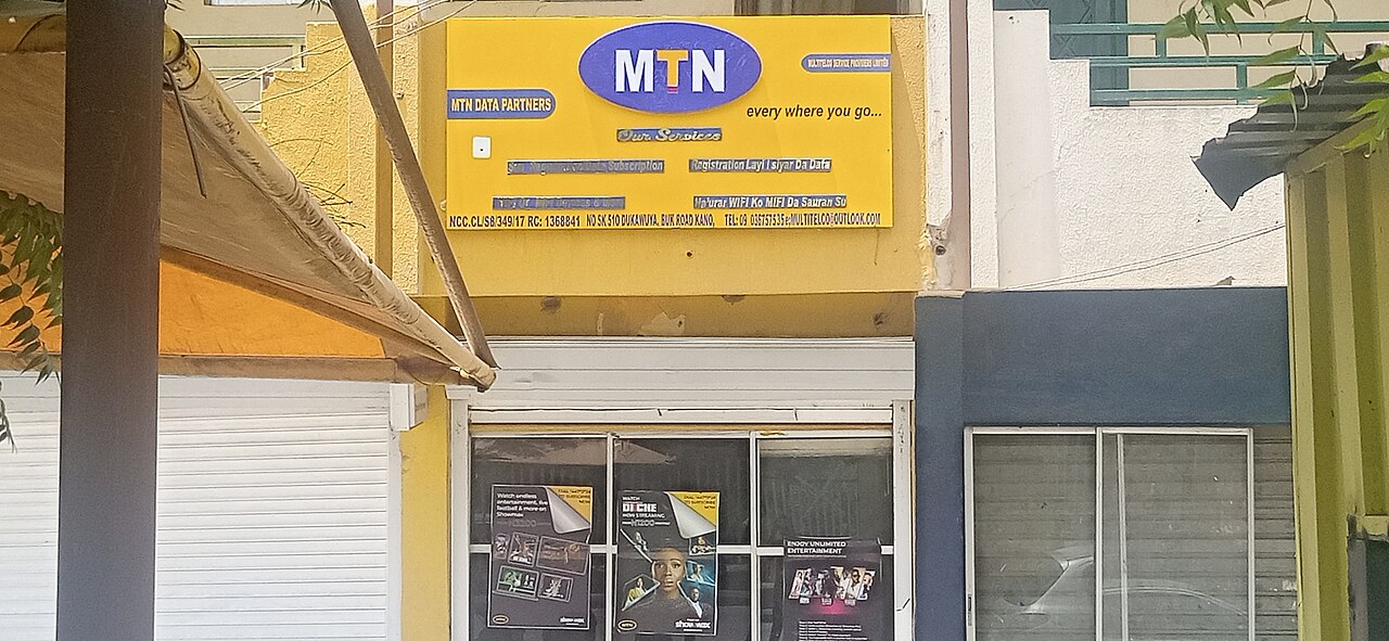 A yellow MTN Data Partners shopfront with the red-and-blue MTN logo on Bukar Road in Kano, Nigeria