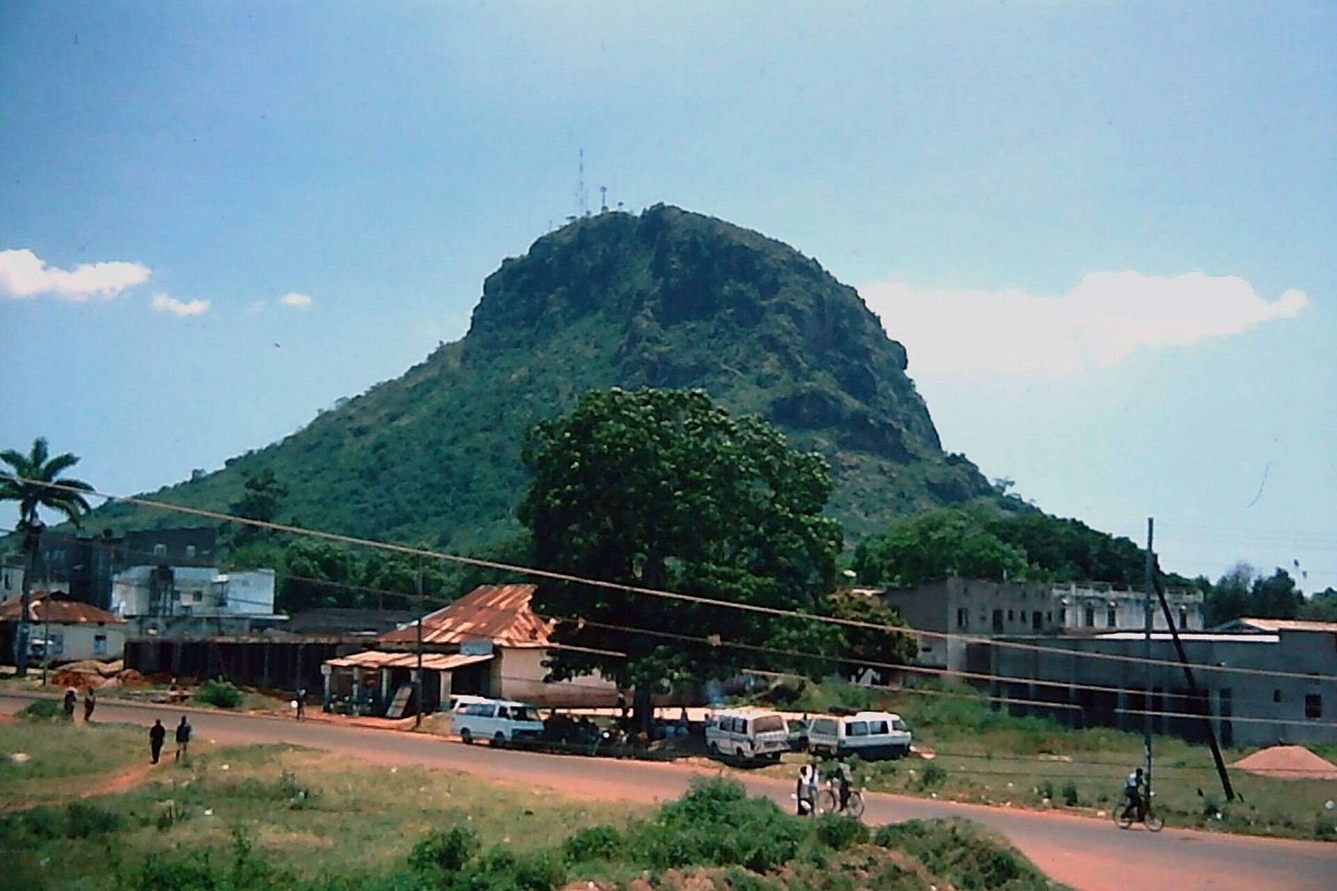 Tororo Rock, a volcanic plug, rising above roadside buildings and minibuses in Tororo town, eastern Uganda