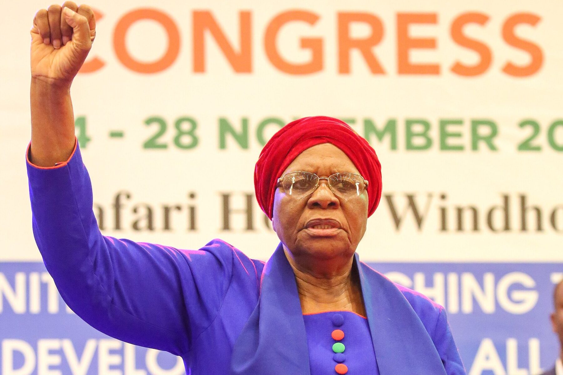 Netumbo Nandi-Ndaitwah raising a clenched fist in a blue dress and red head wrap at the SWAPO Party congress in Windhoek in November 2022
