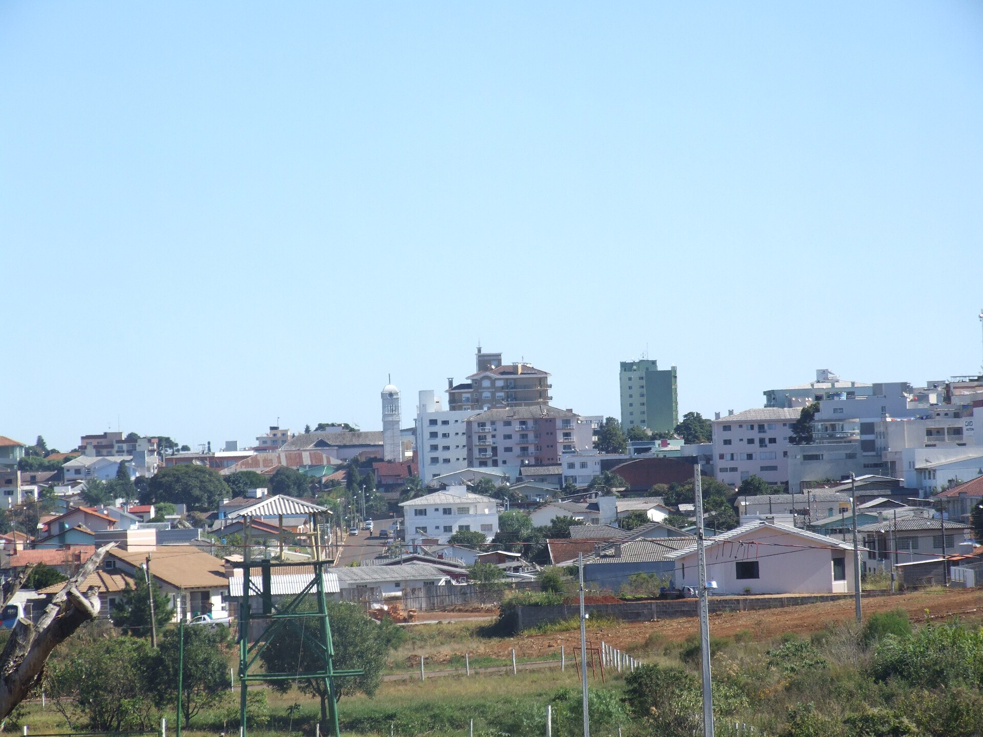 Houses and apartment blocks of Campos Novos on a hillside under a clear blue sky in Santa Catarina, Brazil
