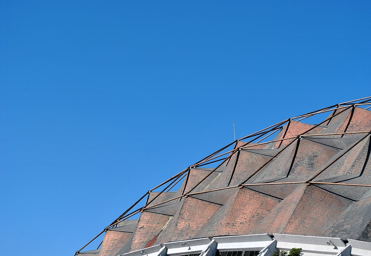 The copper-clad, pyramid-patterned dome of the Palacio de los Deportes in Mexico City under a clear blue sky